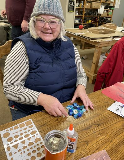 Woman creating a quilled art work using rolled pieces of paper.